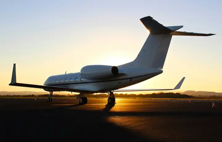 Gulfstream G450 on the ramp, backlit by the setting sun.